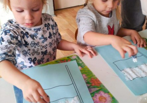 Dziewczynki stemplują taktipalcami białe pasy na flagach Polski