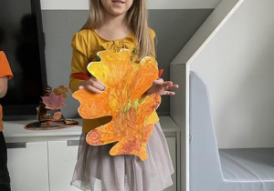 dziewczynka prezentuje pomalowany liść