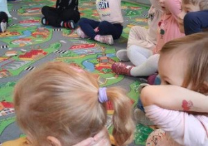 Dzieci ćwiczą zakładanie zaplecionych rąk za głowę
