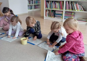 Dzieci kolorują ilustracje zaczerpnięte z opowiadania "Noc w bibliotece"