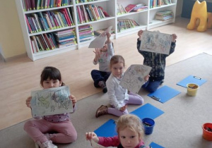 Dzieci pokazują pokolorowane obrazki