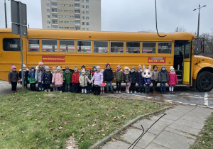 dzieci ustawione w rzędzie przed autobusem w amerykańskim stylu school bus