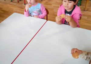 Dziewczynki jedzą biszkopty okrągłe jak koło