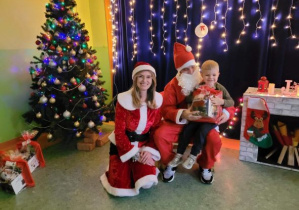 Chłopiec, Mikołaj i Mikołajka na tle świątecznej dekoracji
