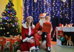 Dziewczynka z Mikołajem i Mikołajką na tle świątecznej dekoracji