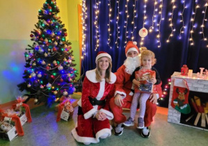 Dziewczynka z Mikołajem i Mikołajką na tle świątecznej iluminacji