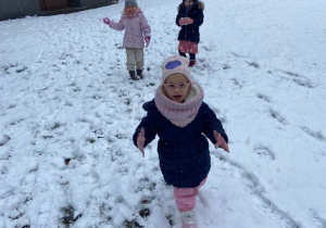 Dziewczynki w ogrodzie przedszkolnym lepią śnieżki