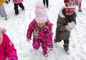 Dzieci lepią śnieżne kulki