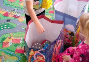 Chłopiec wybiera urodzinowe upominki z kolorowych torebek