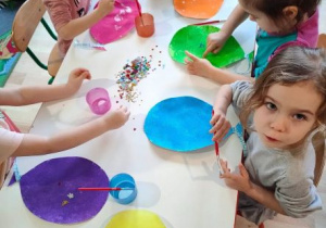 Dzieci ozdabiają kolorowe baloniki cekinami