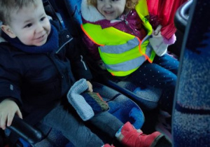 Chłopiec i dziewczynka śmieją się siedząc w autokarze