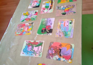 Obrazki pomalowane przez dzieci kolorowymi piaskami