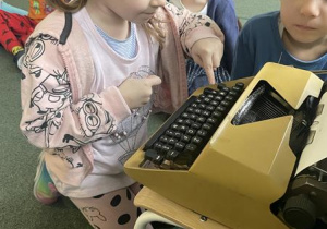 dziewczynka pisze swoje imię na starej maszynie do pisania