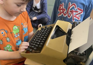 chłopiec pisze swoje imię na starej maszynie do pisania