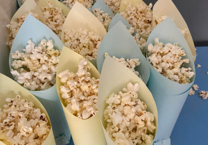 Popcorny poustawiane na stoliku w torebkach