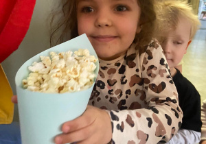 Dziewczynka trzymająca popcorn w torebce
