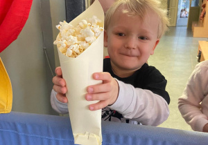Chłopiec trzymający popcorn w torebce