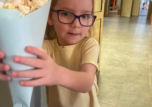 Dziewczynka trzymająca popcorn w torebce