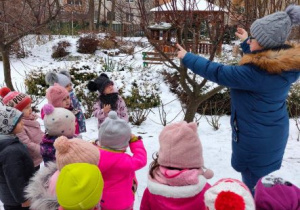 Nauczycielka pokazuje dzieciom karmnik dla ptaków
