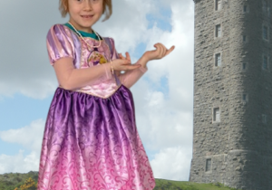 dziewczynka w przebraniu księżniczki na wirtualnym tle z wieżą zamku
