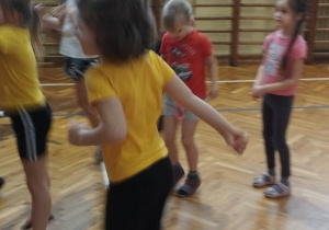 Sala gimnastyczna w Szkole Podstawowej nr164. Dzieci biorą udział w zabawach ruchowych.