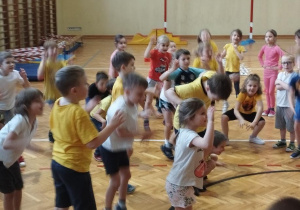 Sala gimnastyczna w Szkole Podstawowej nr164. Dzieci biorą udział w zabawach ruchowych.