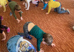 Dzieci chodzą na czworaka po dywanie