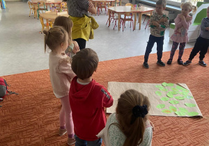 Dzieci na dywanie powtarzają taneczne ruchy