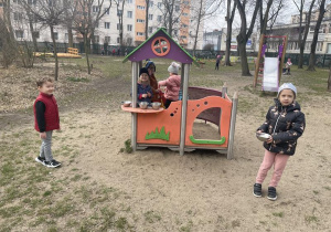 dzieci przy domku na placu zabaw