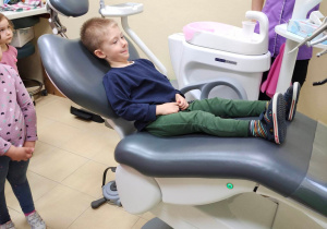 Chłopiec siedzi na fotelu dentystycznym