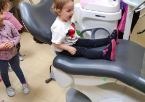 Dziewczynka na podnoszącym się fotelu dentystycznym