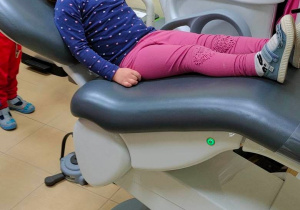 Dziewczynka siedzi na fotelu dentystycznym