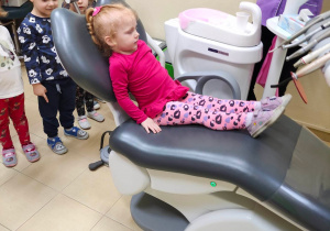 Dziewczynka siedzi na fotelu stomatologicznym