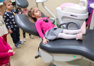 Dziewczynka siedzi na poruszającym się fotelu stomatologicznym