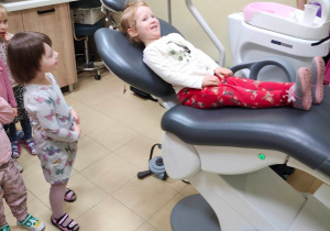 Roześmiana dziewczynka na fotelu dentystycznym