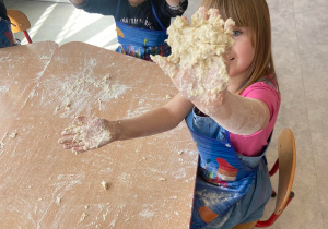 Dziewczynka i chłopiec pokazują ręce w cieście z mąki