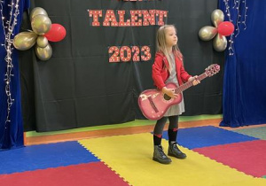 dziewczynka z gitarą występuje na scenie