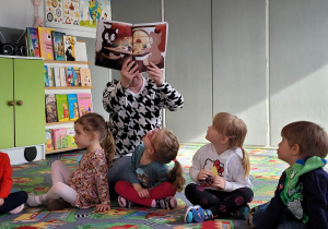 Nauczycielka pokazuje dzieciom ilustrację z książki o Misi i Misiu