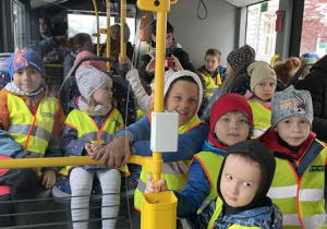dzieci w kamizelkach odblaskowych w autobusie