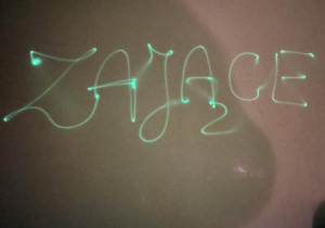 napis "Zające" pisany światłem latarki na farbie fluorescencyjnej