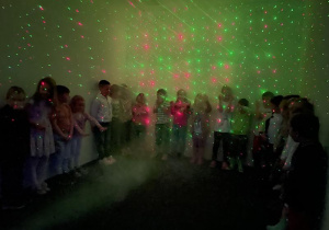 dzieci w pokoju ze światłem i dymem dającymi ciekawy efekt świetlny