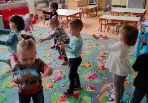 Dzieci tańczą z kolorowymi piórkami