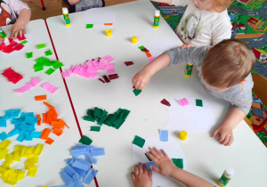 Dzieci wyklejają szablony sów kolorową bibułą