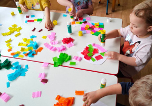 Dzieci wyklejają szablony sów kolorowymi kawałkami bibuły