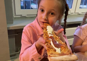 dzieci jedzą pizzę na kolację