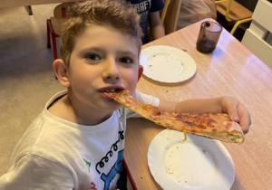 dzieci jedzą pizzę na kolację