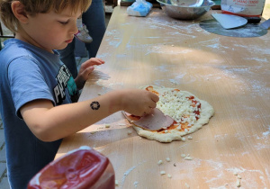 Chłopiec przygotowuje pizzę