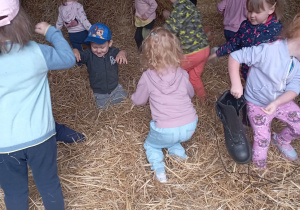 Dzieci podczas zabawy w stodole na słomie