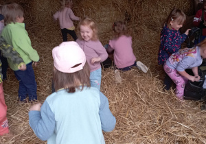 Dzieci podczas zabawy w stodole