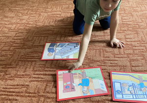 Chłopiec na dywanie układa historykę obrazkową